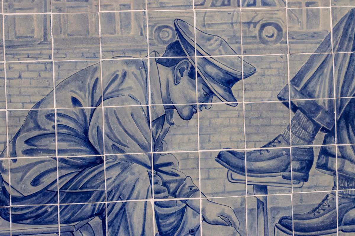 Detail of a mural: a shoeshine man painted in cobalt